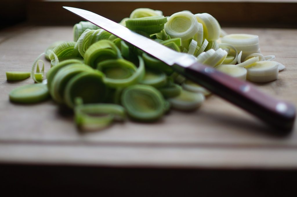 knife sitting atop cut leeks